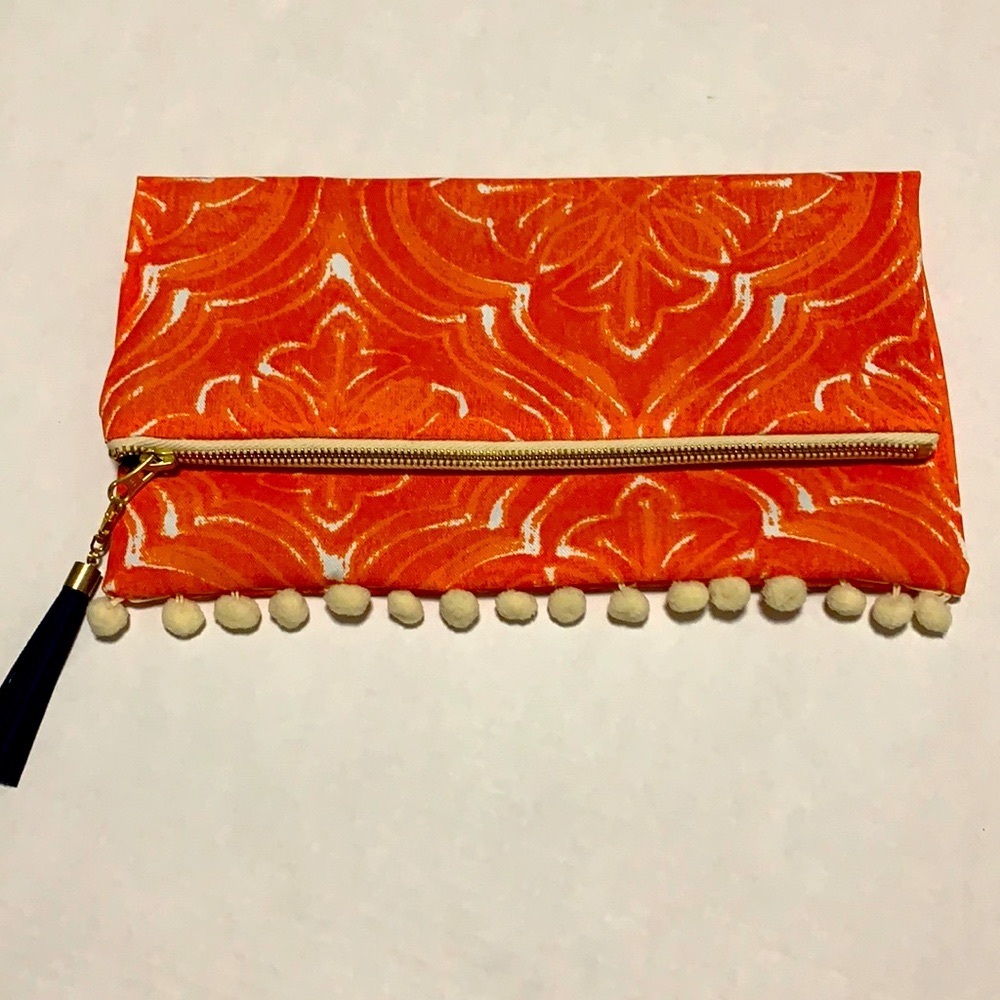 NWOT Orange fold-over Pom Pom clutch